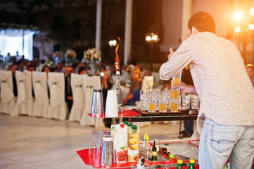 Skillful bartender performing bar tricks in front of a big audience on the wedding.