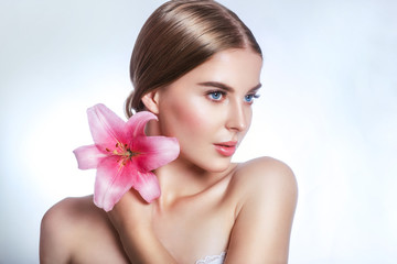 Beauty face of young woman with flower. Beauty treatment concept. Portrait over white background