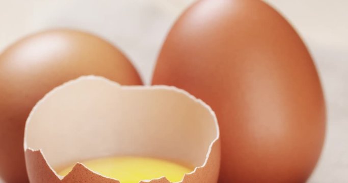raw chicken eggs one open with yolk
