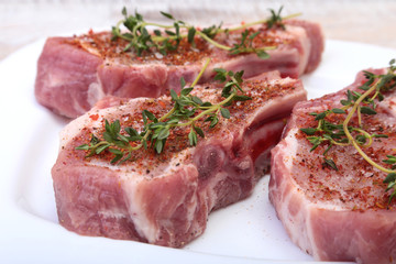Raw pork chops, spices and rosemary on cutting board. Ready for cooking.