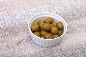 Bowl with fresh olives on wooden background.