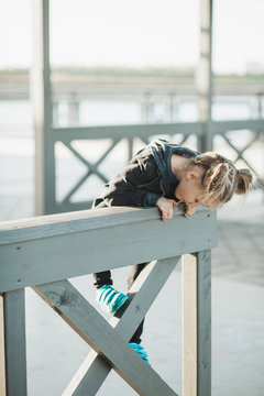 5year old girl climbing the wooden fence on a boardwalk