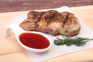 grilled pork chop with Cranberry sauce on plate on wooden board
