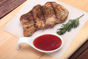 grilled pork chop with Cranberry sauce on plate on wooden board