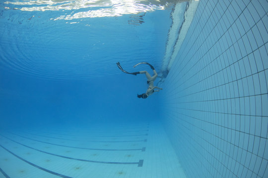 Female freediver swimming underwater in swimming pool