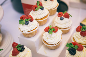 Easter cupcake with raspberries and blueberries on plate, closeup