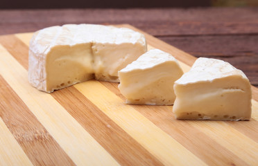 Cheese with white mold. Camembert or brie type on wood table. Healthy breakfast.
