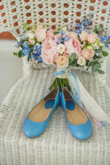 Wedding shoes and bouquet on a white chair