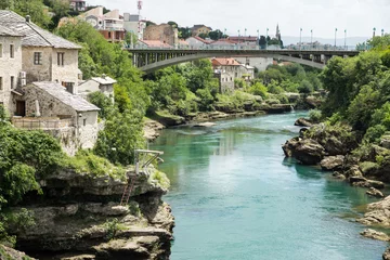 Fotobehang Stari Most Kijkend naar het zuiden vanaf de gereconstrueerde oude brug (Stari Most) over de rivier de Neretva, Mostar, Bosnië en Herzegovina.