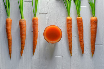 Healthy carrot smoothie in a jar with carrots on white wooden table top view. Healthy food...