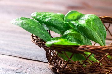 Green fresh spinach leaves on a wooden table