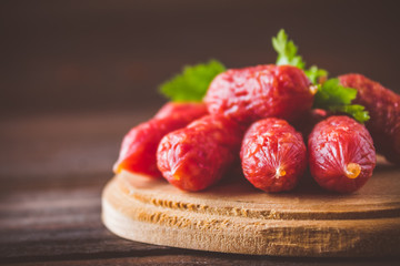 Small smoked sausages on a wooden table
