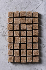 Cane sugar cubes on grey background. Top view.