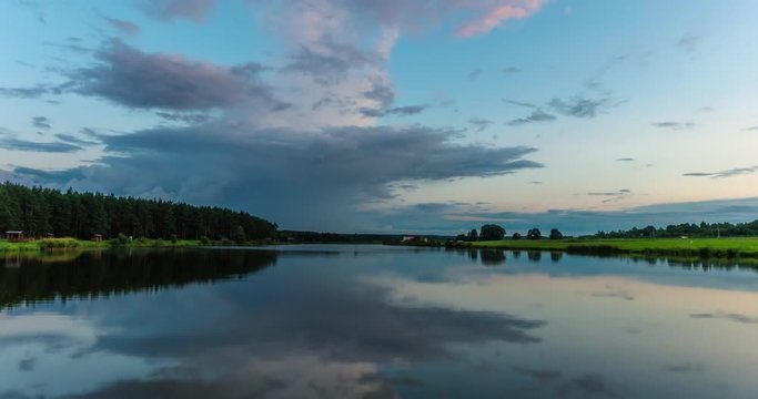 Time lapse clip of evening fluffy curly rolling clouds mirror in lake