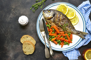 Baked dorado or sea bream with spring vegetables .Top view.