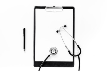 Doctor's accessories. Clip pad and stethoscope on white background top view mockup copyspace