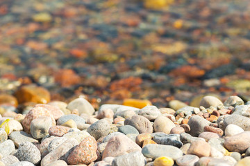 Round stones at seafront, some in the water some at land