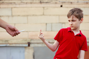 Boy showing middle finger refusing the proposed cigarette. Bad habits, healthcare, stop smoking...