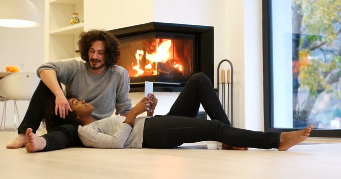 Couple relaxing beside fireplace and having time together