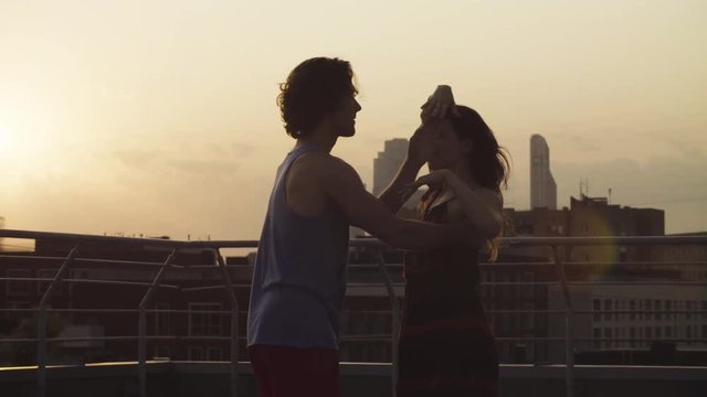 Silhouettes of young couple dancing on sunset