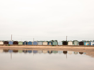 Fototapeta premium beautiful scene of beach huts with reflections in water in front