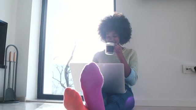 woman sitting on floor and using laptop in modern villa
