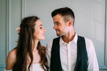 Young and happy newlyweds look at each other with love