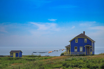 Fototapeta na wymiar Cute blue house with washing line facing the see