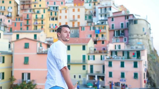 Young tourist man with great view of stunning village of Manarola, Cinque Terre, Liguria, Italy