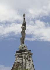 A woman naked figure statue holding a torch