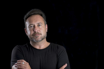 Bearded Man in Black Shirt over Black Background Copy Space