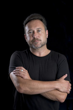 Adult Male in Black Shirt Crossed Arms Black Background