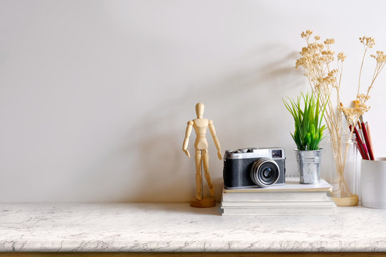 Mock up modern home decor with camera, dummy, houseplant. Artist workspace with copy space for products display montage.