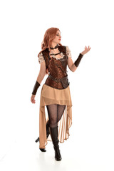 full length portrait of red haired lady wearing steampunk inspired outfit, standing pose against a white background.