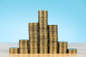 coins stack on wooden table and light blue background