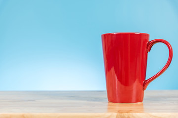 red coffee cup on wooden table background