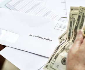 Middle Aged Woman panicking while Holding Bills Due and Currency