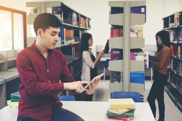 Young students doing using tablet pc at library.