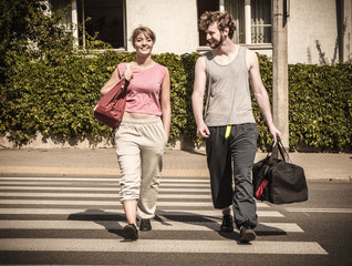 Happy couple man and woman with sport bags.