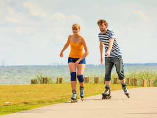 Young couple on roller skates riding outdoors