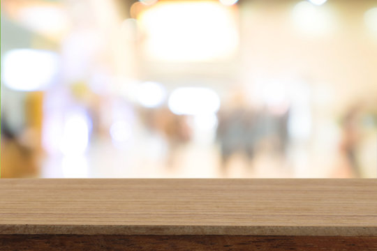Perspective wooden table on top over blur coffee shop background, can be used mock up for montage products display or design layout.