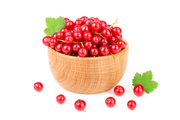 Red currant berries in a wooden bowl with leaf isolated on white background