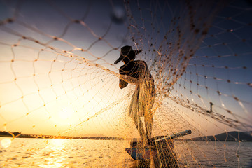 Fisherman on a fishing boat in a river at sunset,Thailand