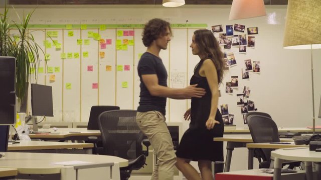 Couple dancing in the office.