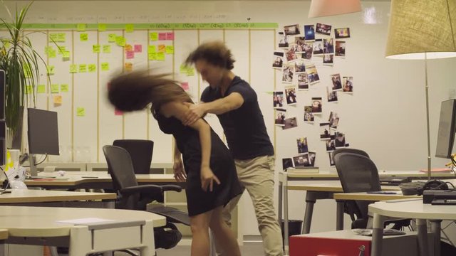 Couple dancing in the office.