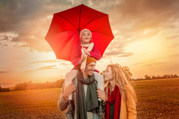 Familie im Herbst mit Regenschirm