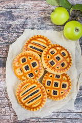  Homemade baking. Biscuits with apple jam and fresh green apples on an old wooden table.
