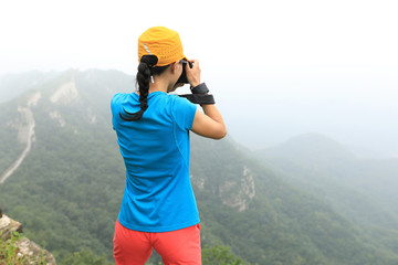 young woman photographer taking photo on great wall