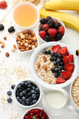 Oat flakes with berries, honey and nuts on wooden table