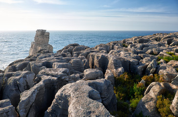 Fototapeta na wymiar Rocks and waves of surf in the ocean near Cabo Carvoeiro, Peniche peninsula, Portugal